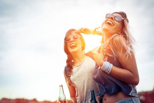 Happy friends laughing and having fun outdoors at concert