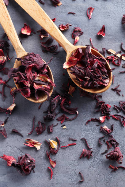 istock Heap of dry tea with wooden spoon on grey table 665365182