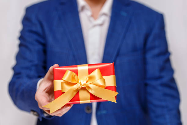 istock Male hand holding a red gift box with ribbon. 665365808
