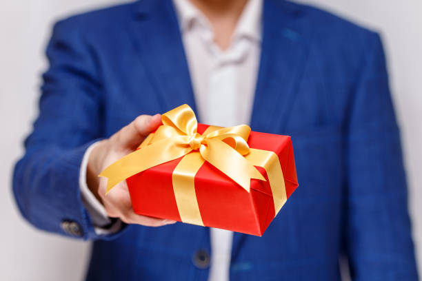 istock Male hand holding a red gift box with ribbon. 665365838