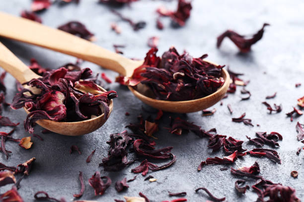 istock Heap of dry tea with wooden spoon on grey table 665371392