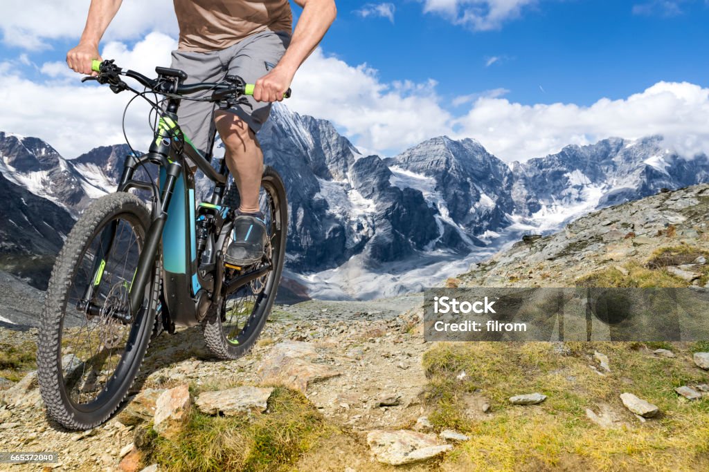 e bike rider mountain trail Single mountain bike rider on E bike rides up a steep mountain trail. Electric Bicycle Stock Photo