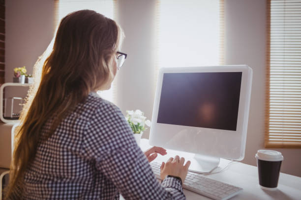istock Rear view of hipster businesswoman typing on computer 665389968