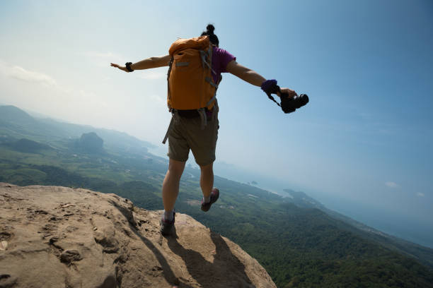 istock cheering young woman backpacker enjoy the view on sunrise mountain peak 665390788