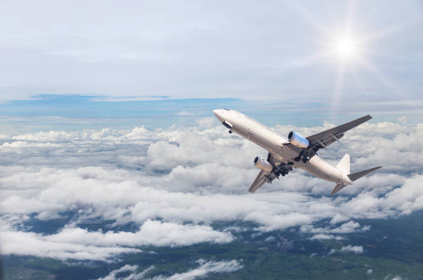 istock airplane flying in to sky above the white clouds 665393422