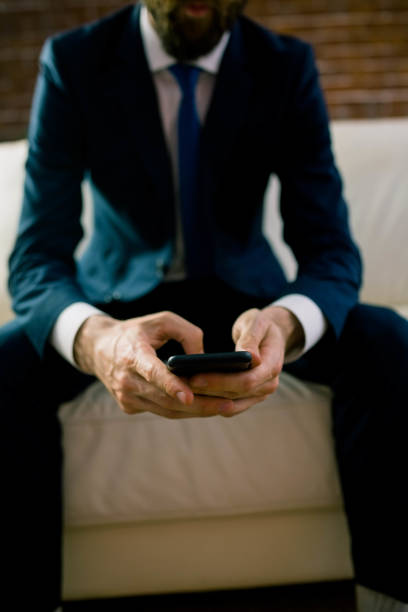 istock Businessman texting on the couch 665397352
