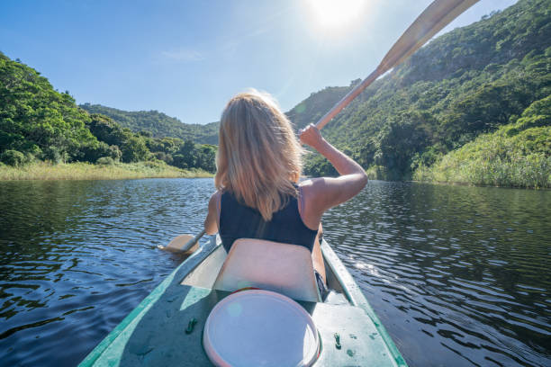 istock Woman paddling canoe on river, summer 665397584