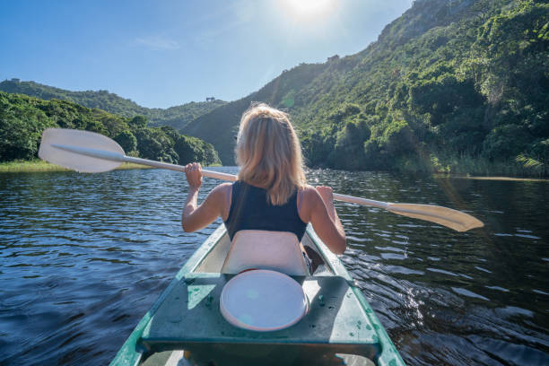 istock Rear view of young woman canoeing 665397616