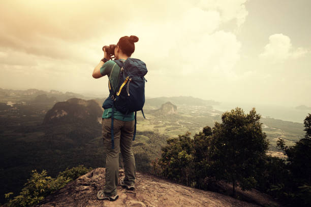 istock young woman backpacker taking photo on sunrise mountain peak 665398890