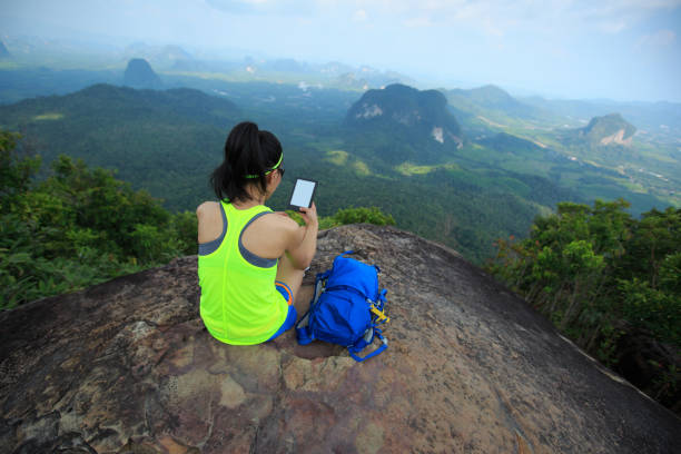 istock successful woman hiker reading e-book on mountain top 665401968