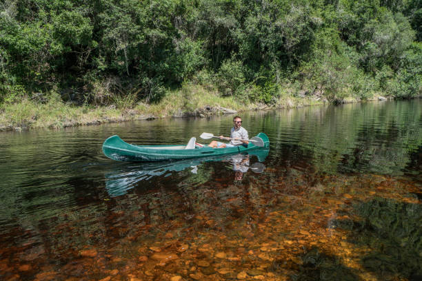 istock One young man paddling canoe on river 665402186