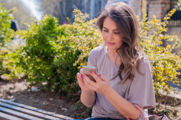 istock Attractive woman using cellphone outdoors. 665402552