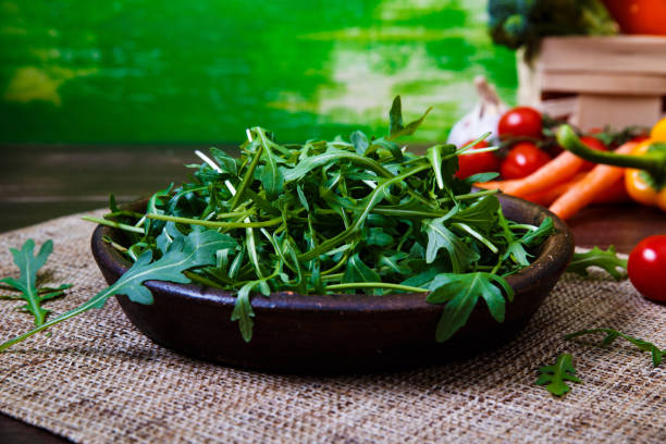 istock Green arugula leaves in bowl. Fresh salad. 665405314