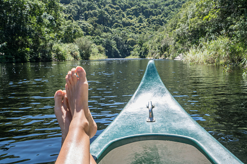 Personal perspective of young woman canoeing on river in South Africa. Beautiful summer day.