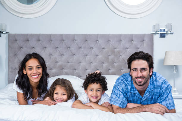istock Smiling family laying on the bed 665409932