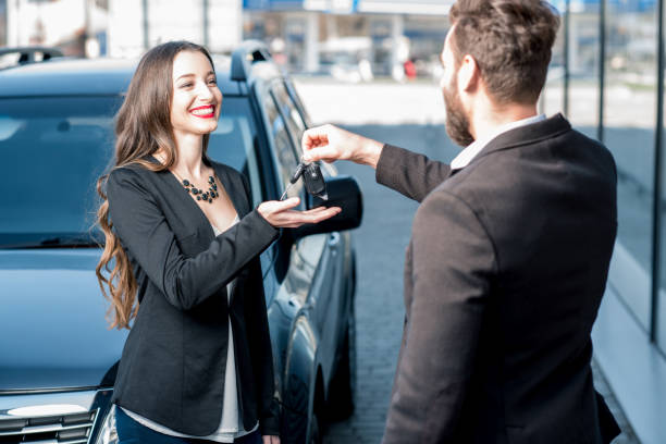 zufriedener kunde und verkäufer in der nähe von auto - car car rental car dealership key stock-fotos und bilder