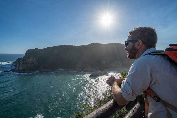 istock Young man traveling looks at coastline 665411148