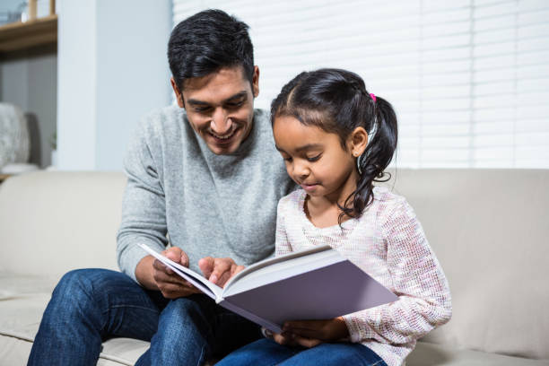 istock Happy father and daughter using laptop on the sofa 665414354