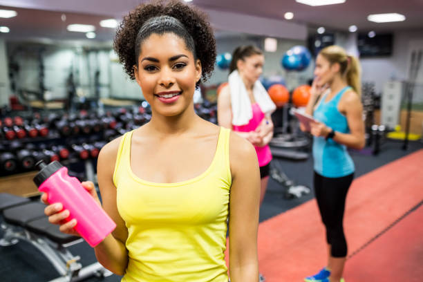 istock Fit woman smiling at camera in weights room 665414898