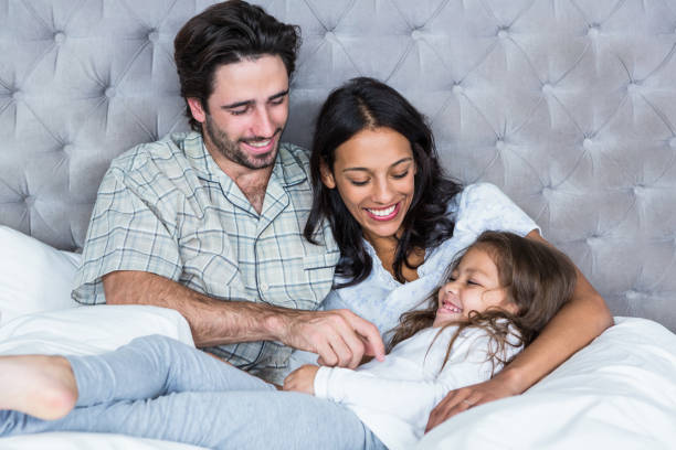 istock Happy parents tickling daughter 665418372