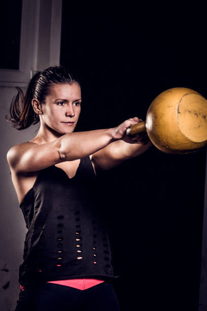 istock Young woman on training with kettlebell in gym 665418422