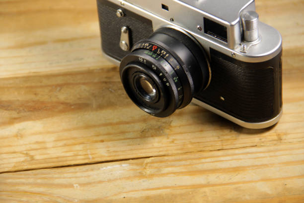 istock Retro photo camera on wooden background 665422044