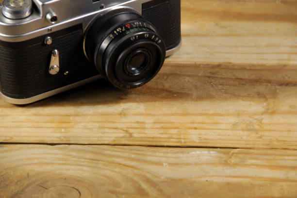 istock Retro photo camera on wooden background 665422046