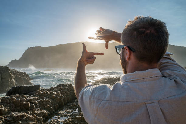istock Young man traveling frames sunset with hands 665425000