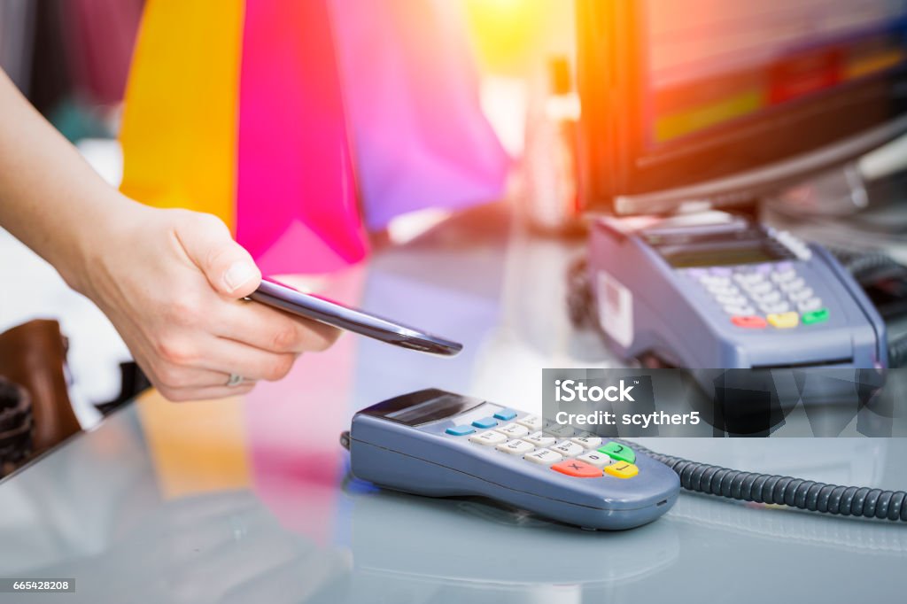 Near field communication (NFC) mobile phone payment. mobile payment phone retail nfc pay paying smart shopping reader woman wireless concept - stock image Contactless Payment Stock Photo