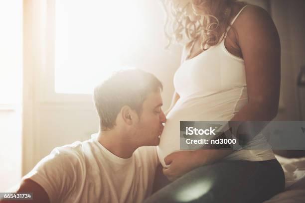 Husband Kissing Newborn Through Wife Belly Stock Photo - Download Image Now - Pregnant, Father, Kissing