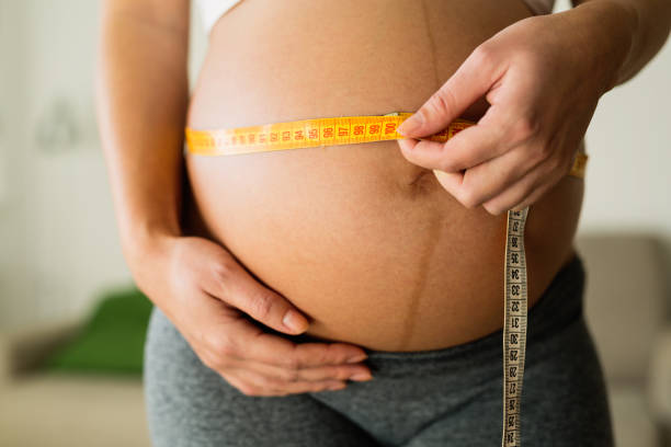istock Pregnant woman measuring belly growth 665431982