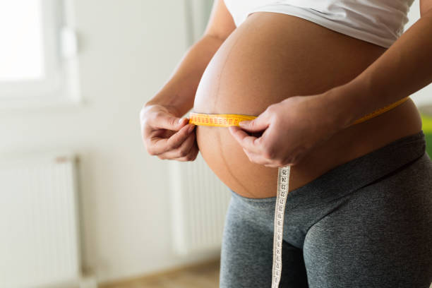 istock Pregnant woman measuring belly growth 665431992