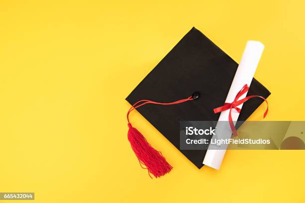 Photo libre de droit de Vue De Dessus Du Mortier Graduation Et Diplôme Sur Fond Jaune Le Concept De Léducation banque d'images et plus d'images libres de droit de Toque de diplômé