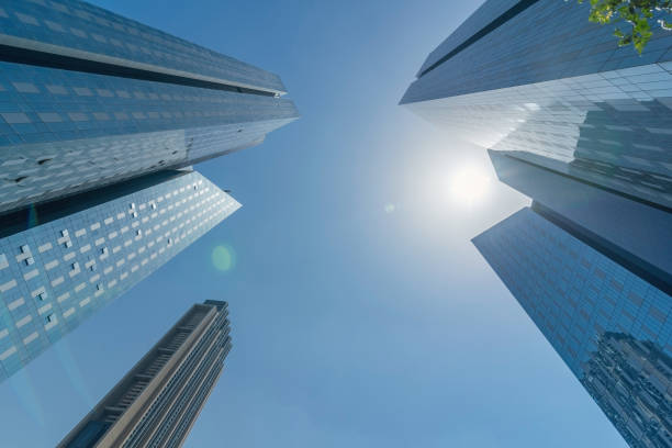Infinite Corporate Buildings. Business offices skyscrapers on blue sky background. Low angle view of tall corporate buildings. stock photo