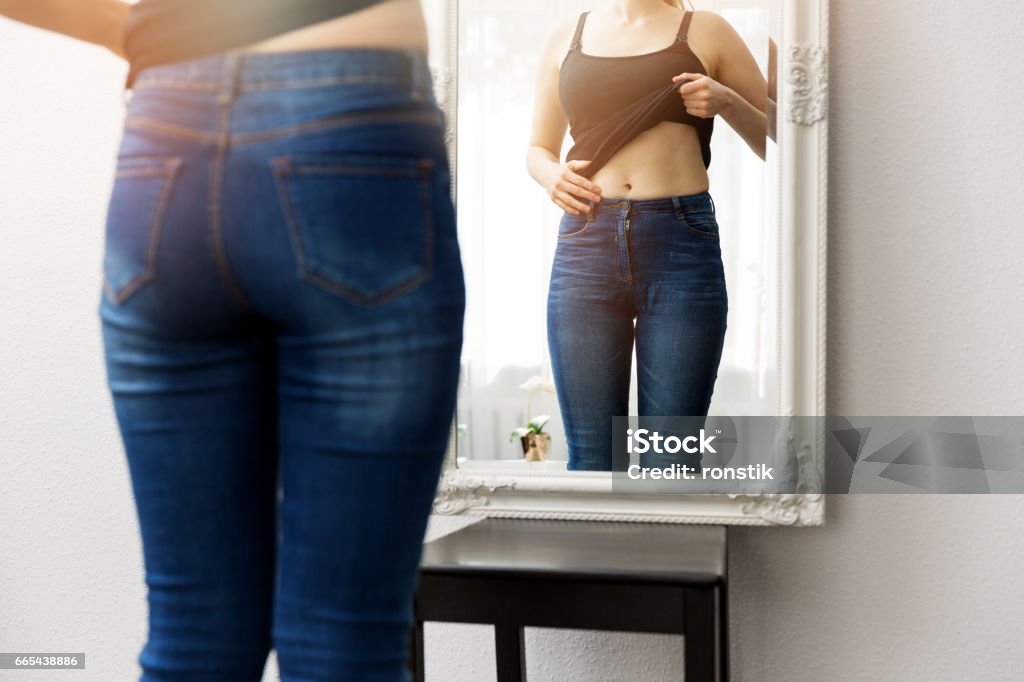 woman checking her body in front of mirror Mirror - Object Stock Photo