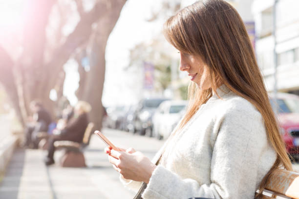 istock Young woman using smart phone at street 665453196