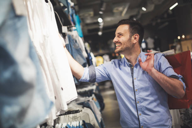 Handsome man shopping for new clothes in store