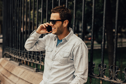 Man in plain shirt is talking on the phone