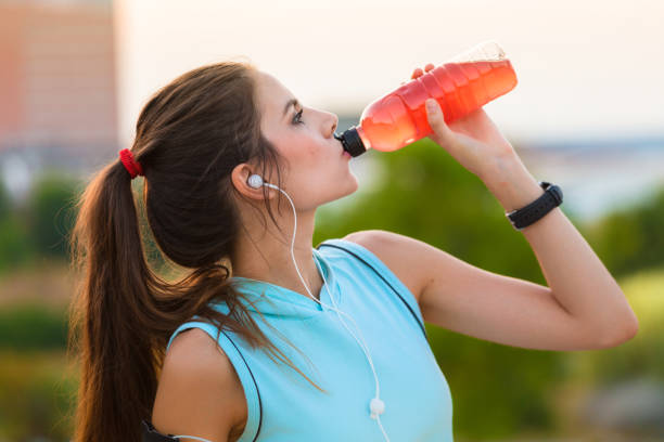 istock Woman resting and drinking after running 665475410