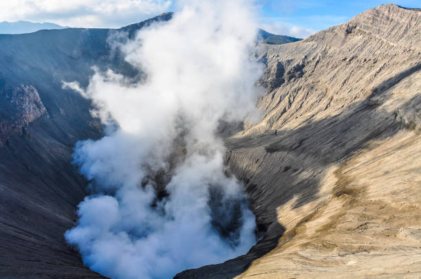 пары, выходят из активного вулкана бромо на яве, индонезия - bromo crater стоковые фото и изображения