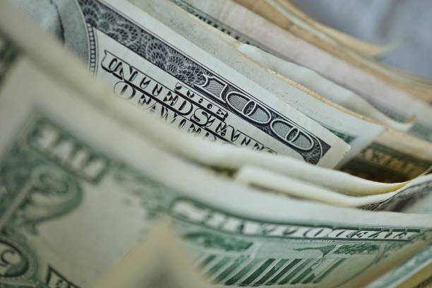 Macro detail of a one hundred dollar bank note in a row with many other bank notes