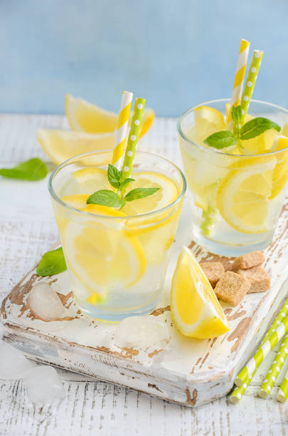 istock Cold refreshing summer drink with lemon and mint on wooden background. 665486298