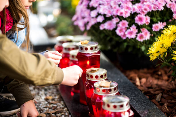 kids and candles by the grave - cemetery imagens e fotografias de stock