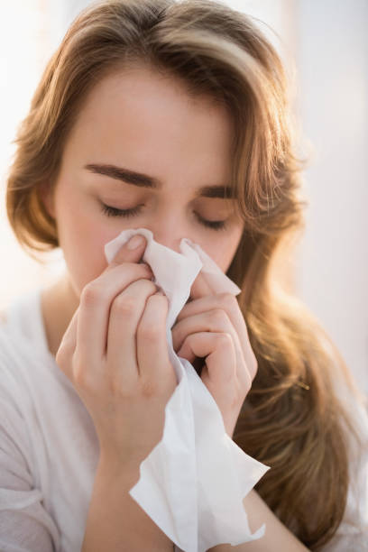 istock Woman blowing her nose on couch 665497740