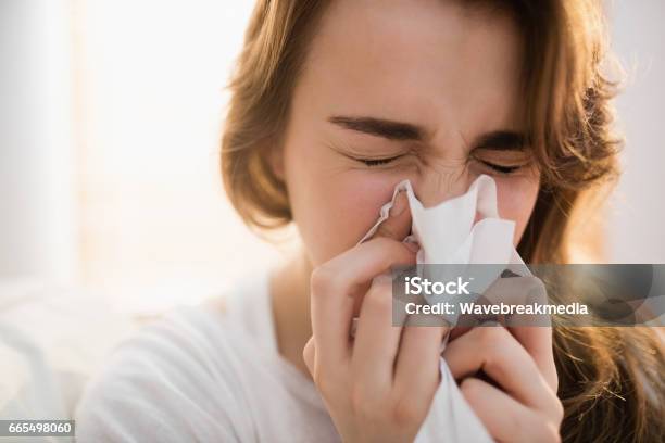 Woman Blowing Her Nose On Couch Stock Photo - Download Image Now - Hay Fever, Blowing Nose, Sneezing
