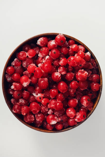 istock Frozen redcurrant with frost in wooden bowl 665500032