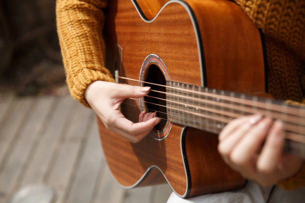 istock Young woman playing guitar 665507070