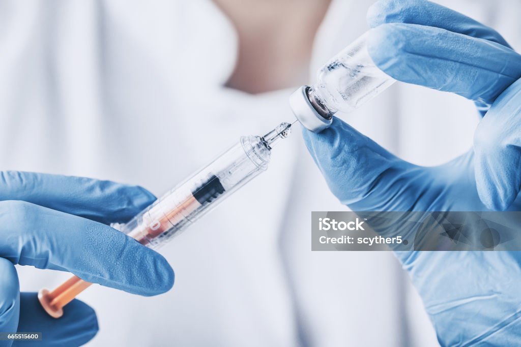 injecting injection vaccine vaccination medicine flu woman docto injecting injection vaccine vaccination medicine flu man doctor insulin health drug influenza concept - stock image Syringe Stock Photo