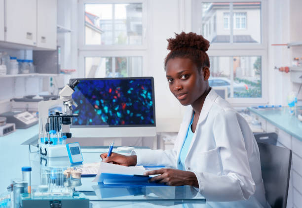 científico africano femenino trabaja en moderno laboratorio biológico - microplate fotografías e imágenes de stock