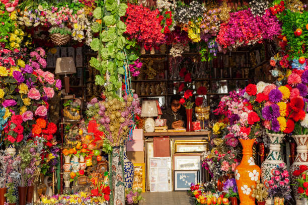 A beautifully arranged display of artificial flowers fills the shelves of a home decor shop, showcasing the creativity and charm of sustainable decor options. This vibrant scene highlights the role of small businesses in promoting environmentally friendly choices, with a focus on zero-waste and reusable materials.
